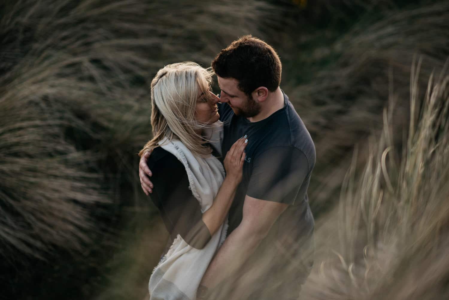 couple looking at each other on sand dunes 