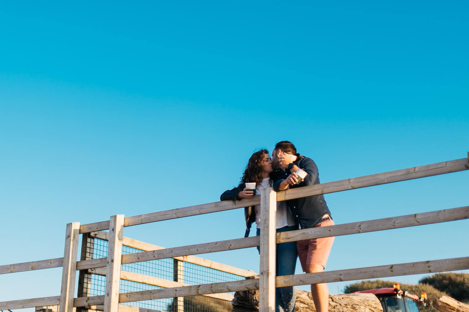 couple kissing blue sky engagement photos