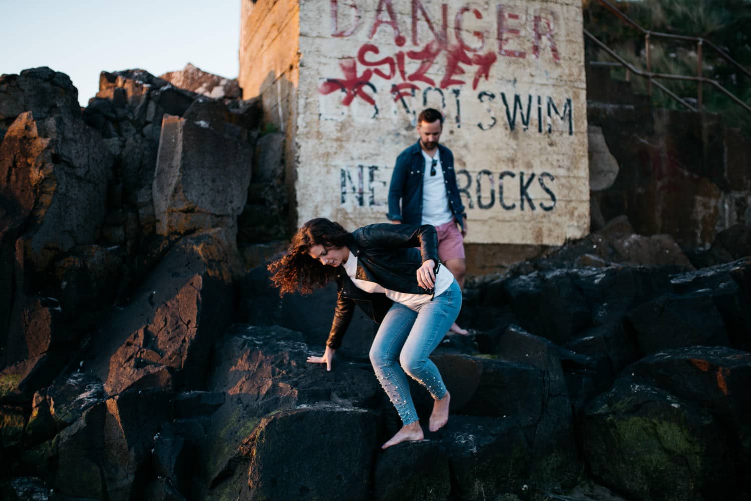 couple climbing over rocks