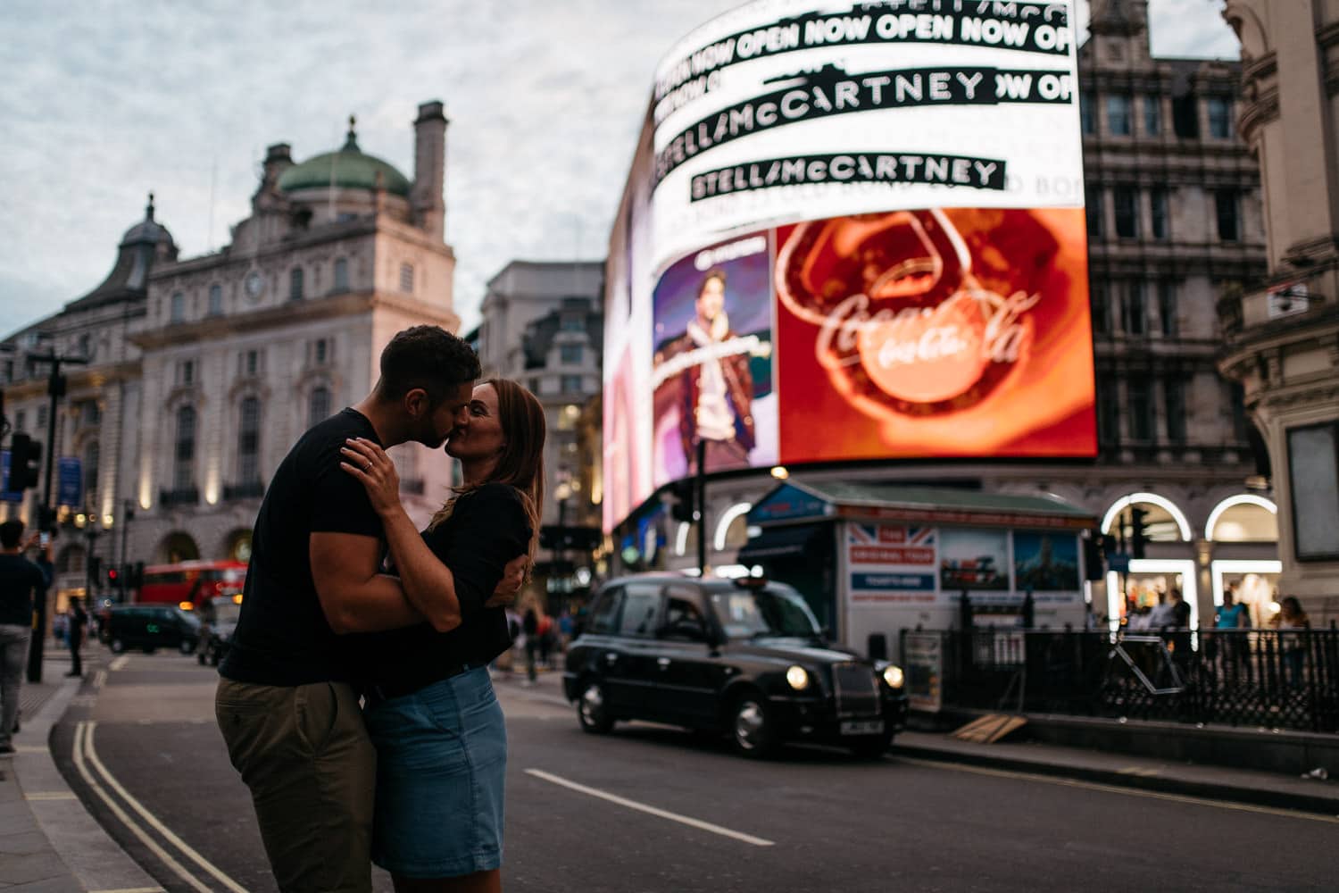 couple kissing in front of screens Engagement Photography Soho London