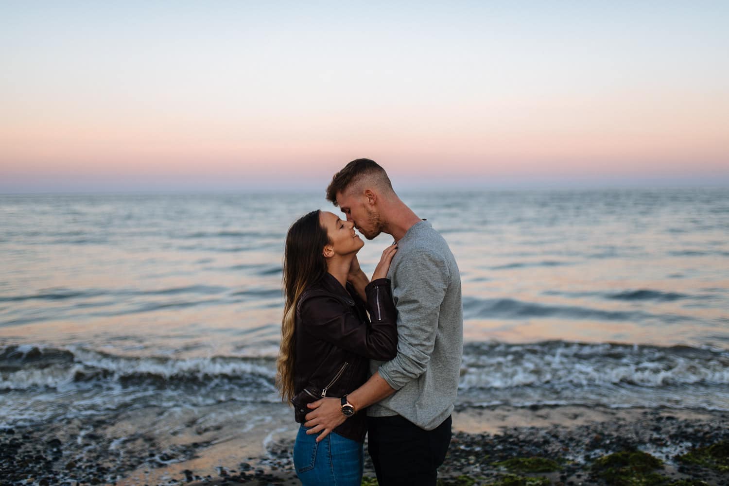 half kisses at sunset at the sea Engagement Photography Belfast