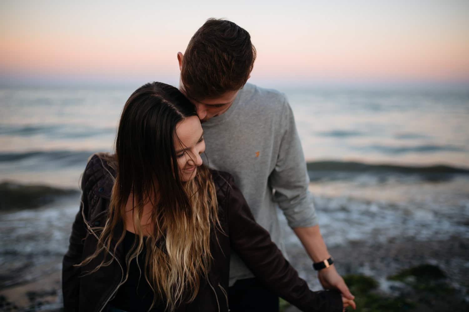 couple being intimate at sunset at the sea Belfast Engagement Photography