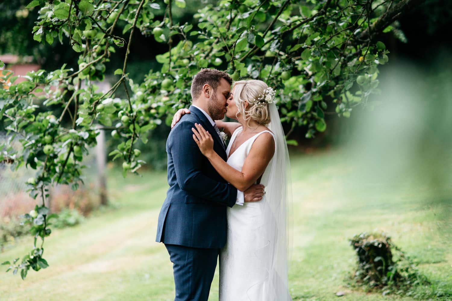 bride and groom kissing under apple tree Wedding Photography Northern Ireland