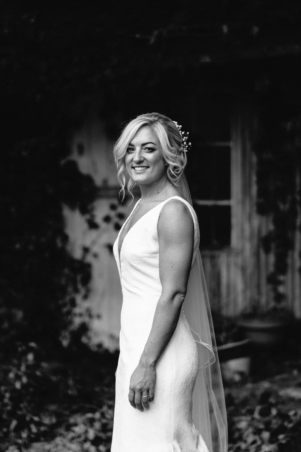 bride standing in garden black and white