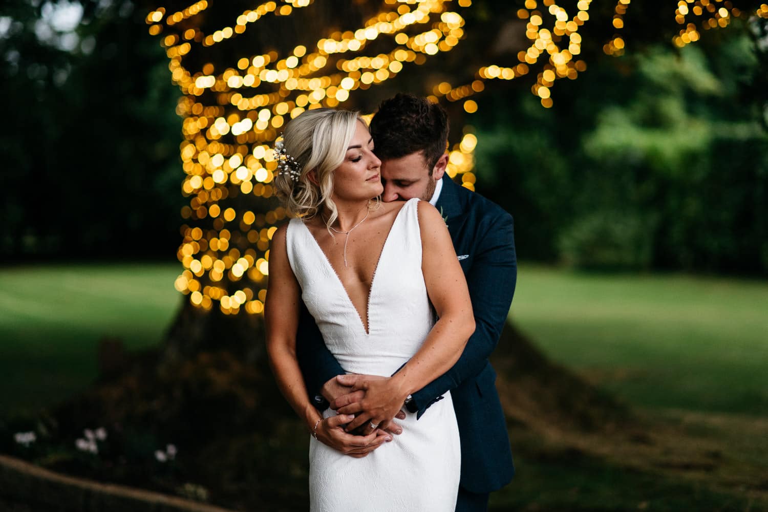 bride and groom hugging in front of tree Wedding Photographer Northern Ireland