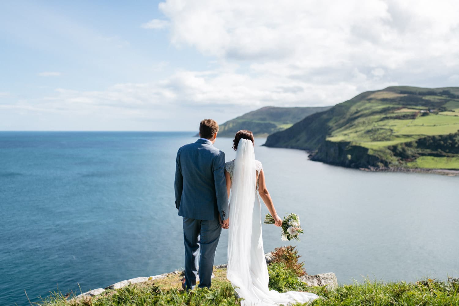 bride and groom looking into the ocean Lissanoure Castle Wedding Photographer