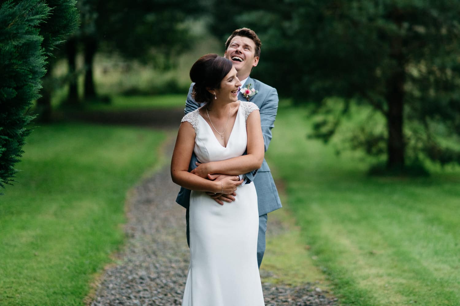 bride and groom laughing down the lane Lissanoure Castle Wedding Photography