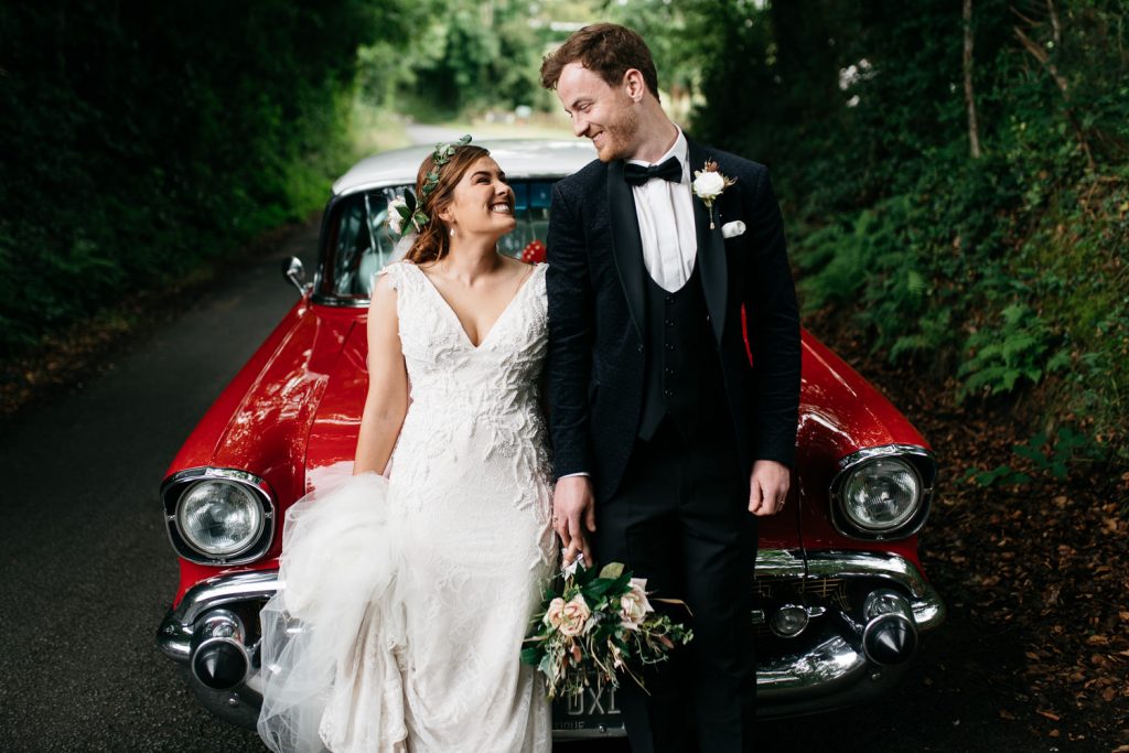 bride and groom standing in front of a car dding photos Northern Ireland Wedding Photographers