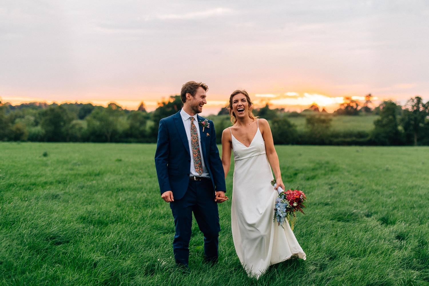 bride and groom laughing holding hands at sunset Gracehall Wedding Photography