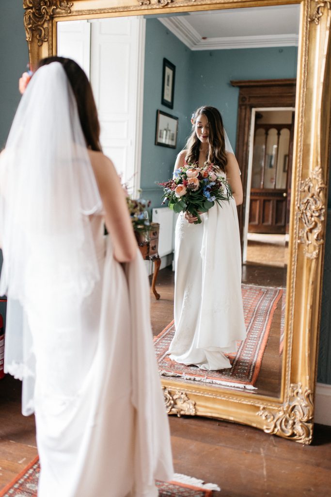 bride standing in front of the mirror holding her flowers Ivory Pavilion Wedding