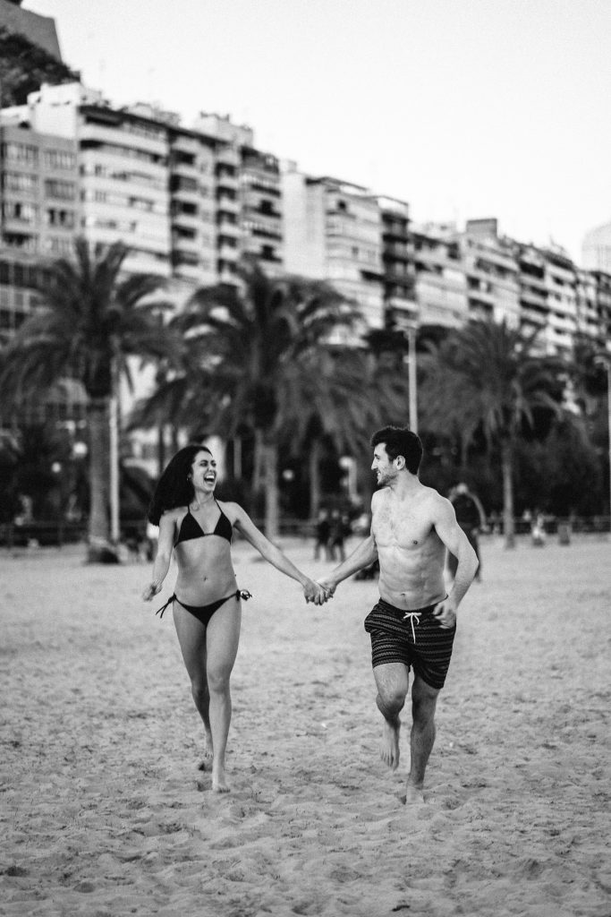 couple running on the beach holding hands Barcelona Wedding Photographer