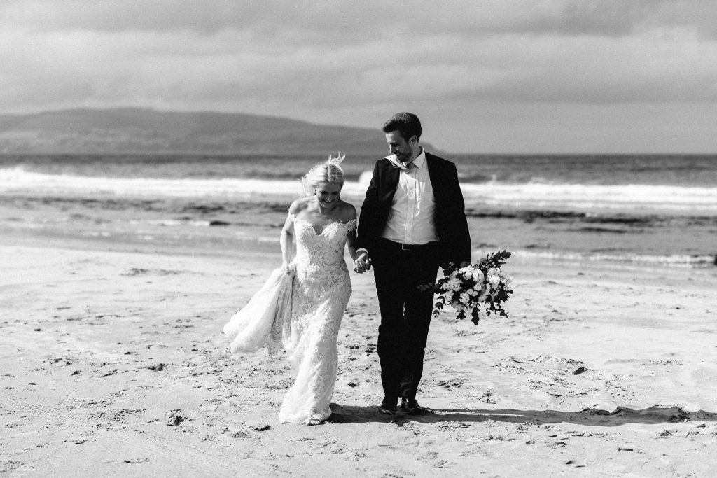 couple walking and laughing on the beach Elopement Photographer Ireland