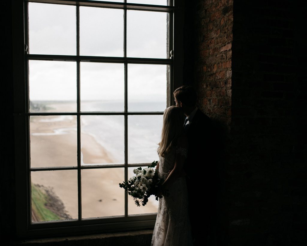 couple looking off onto the beach from Mussenden temple Northern Ireland Elopement Photographers