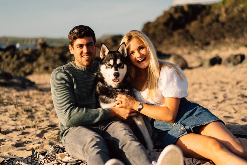couple posing with husky don on their engagement shoot Northern Ireland Wedding & Engagement Photographer