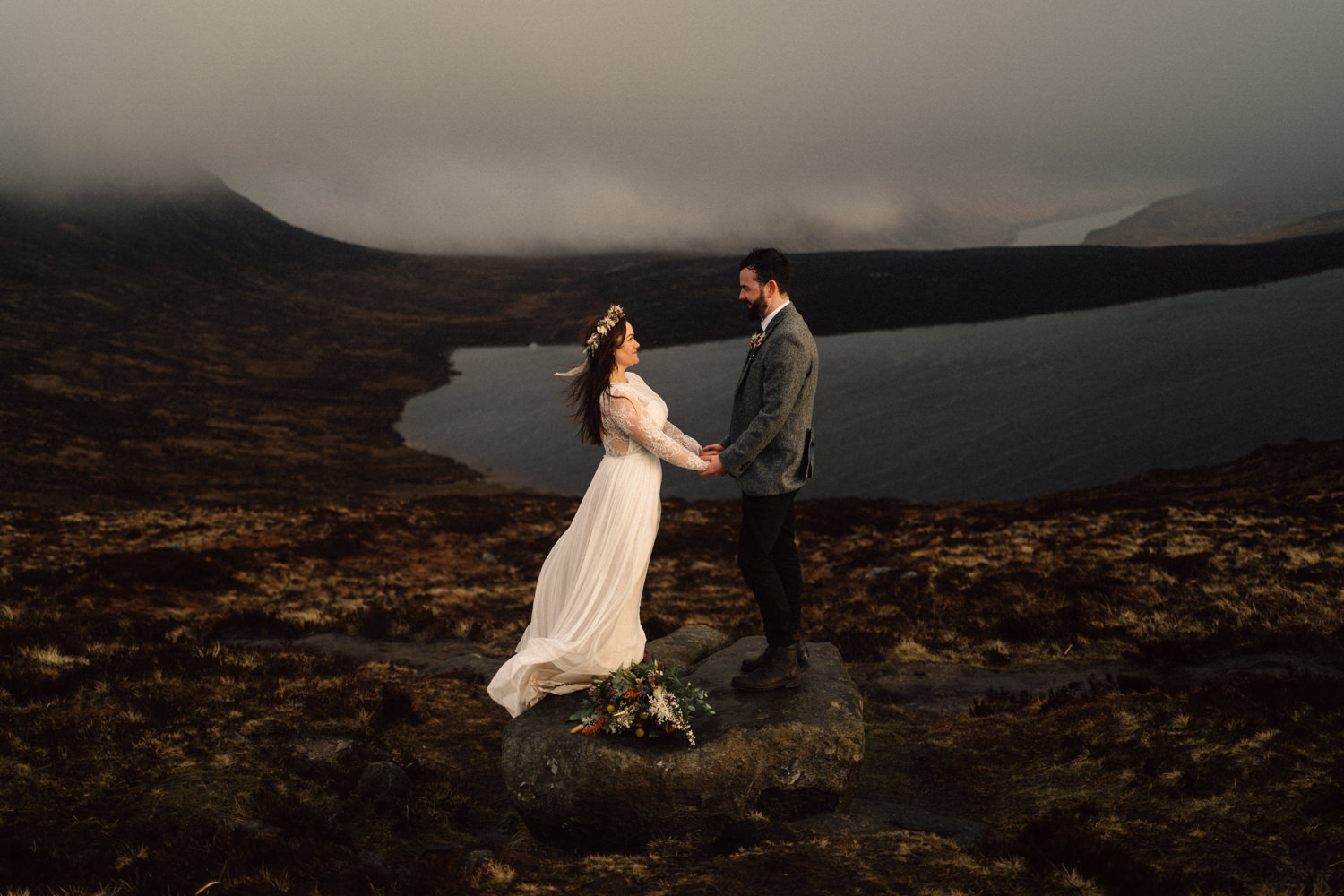 bride and groom holding hands over looking lough shannagh 