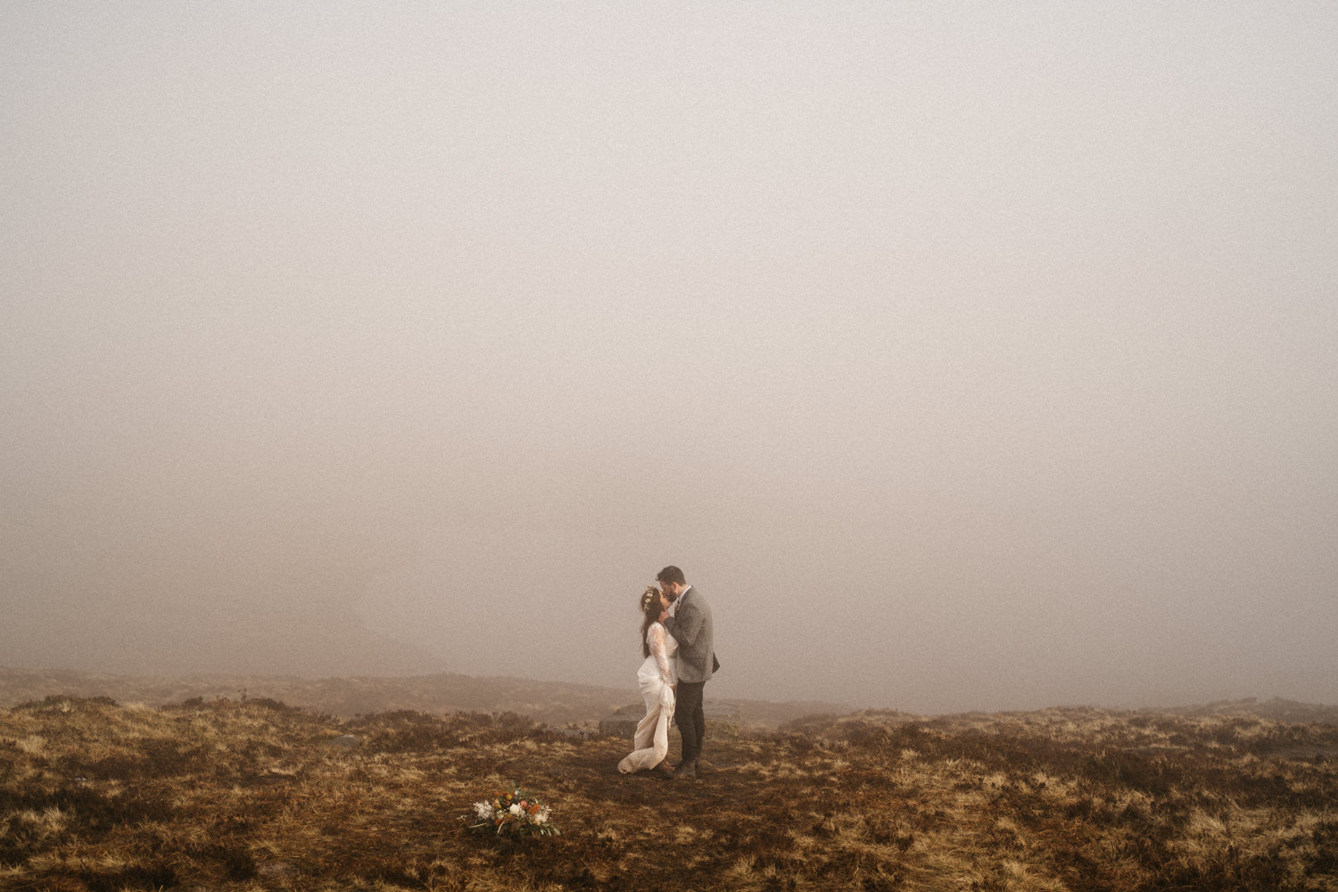 bride and groom kissing over looking Lough Shannagh