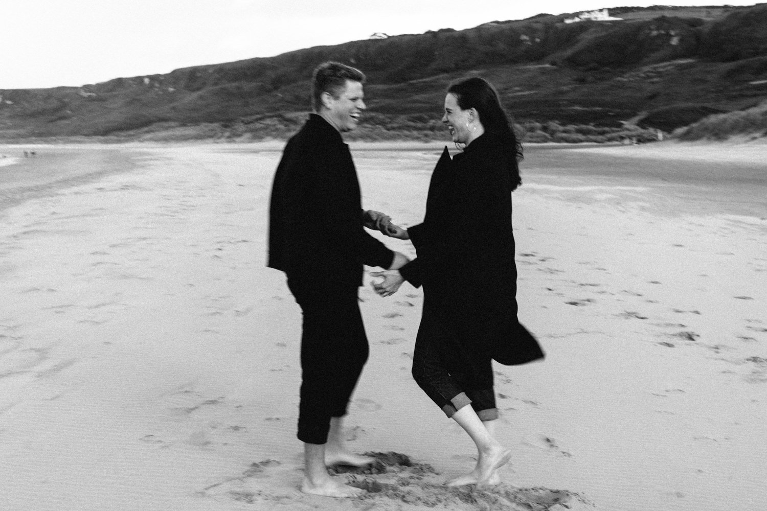 couple laughing holding hands on the beach white park bay  Elopement Photographer - Couples Photographer