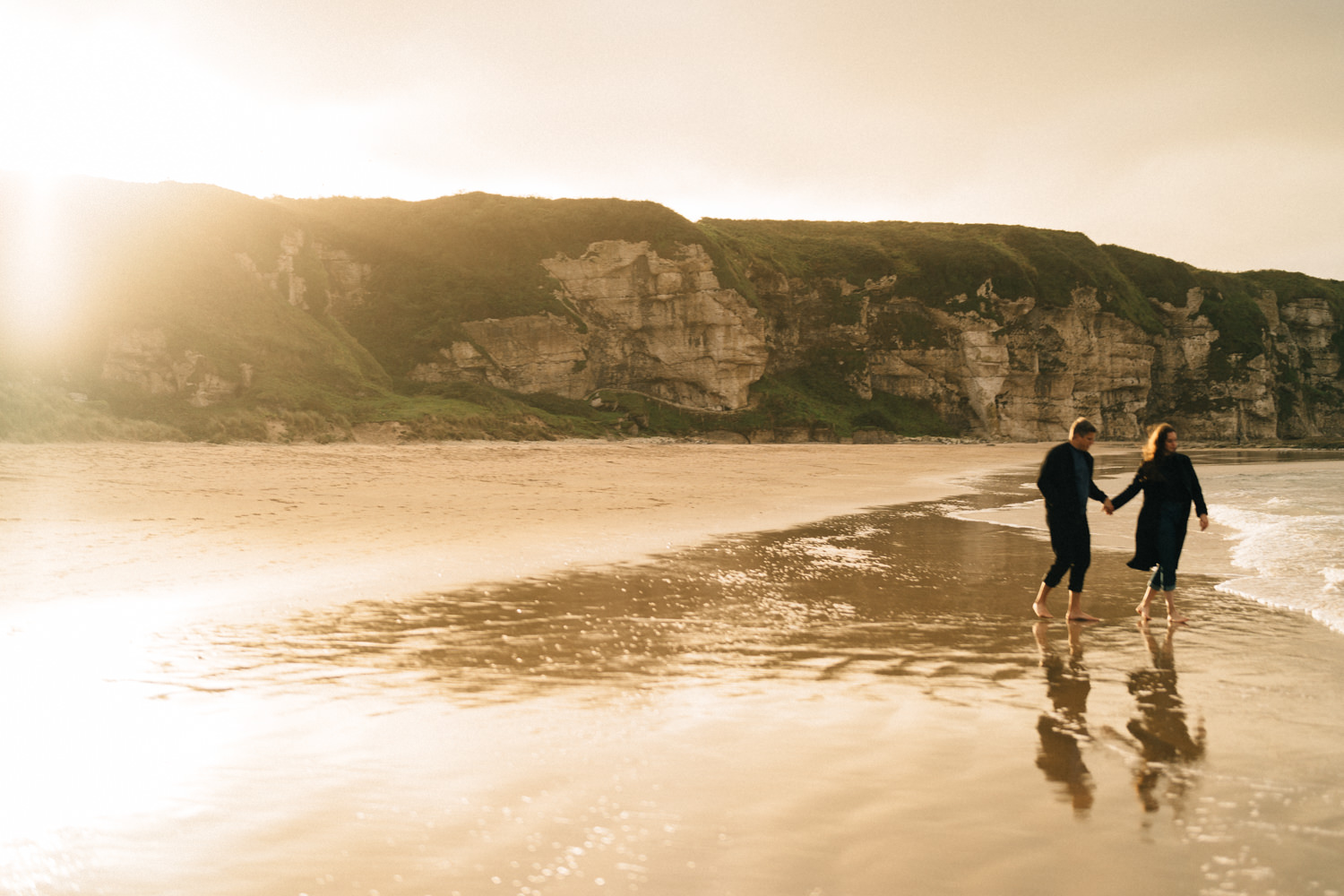 couple waling through the sea at white park bay beach  Elopement Photographer - Couples Photographer