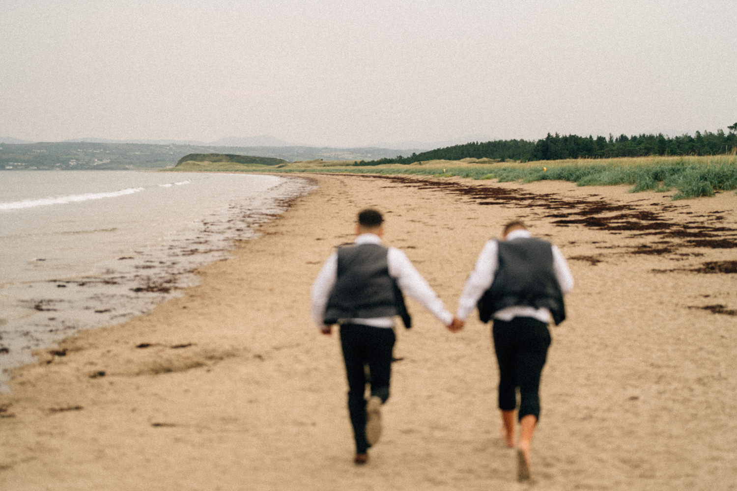 grooms running on the beach wedding photographers northern ireland