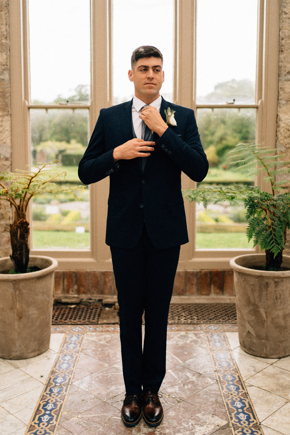 Groom fixing his tie Weddings at Killruddery House