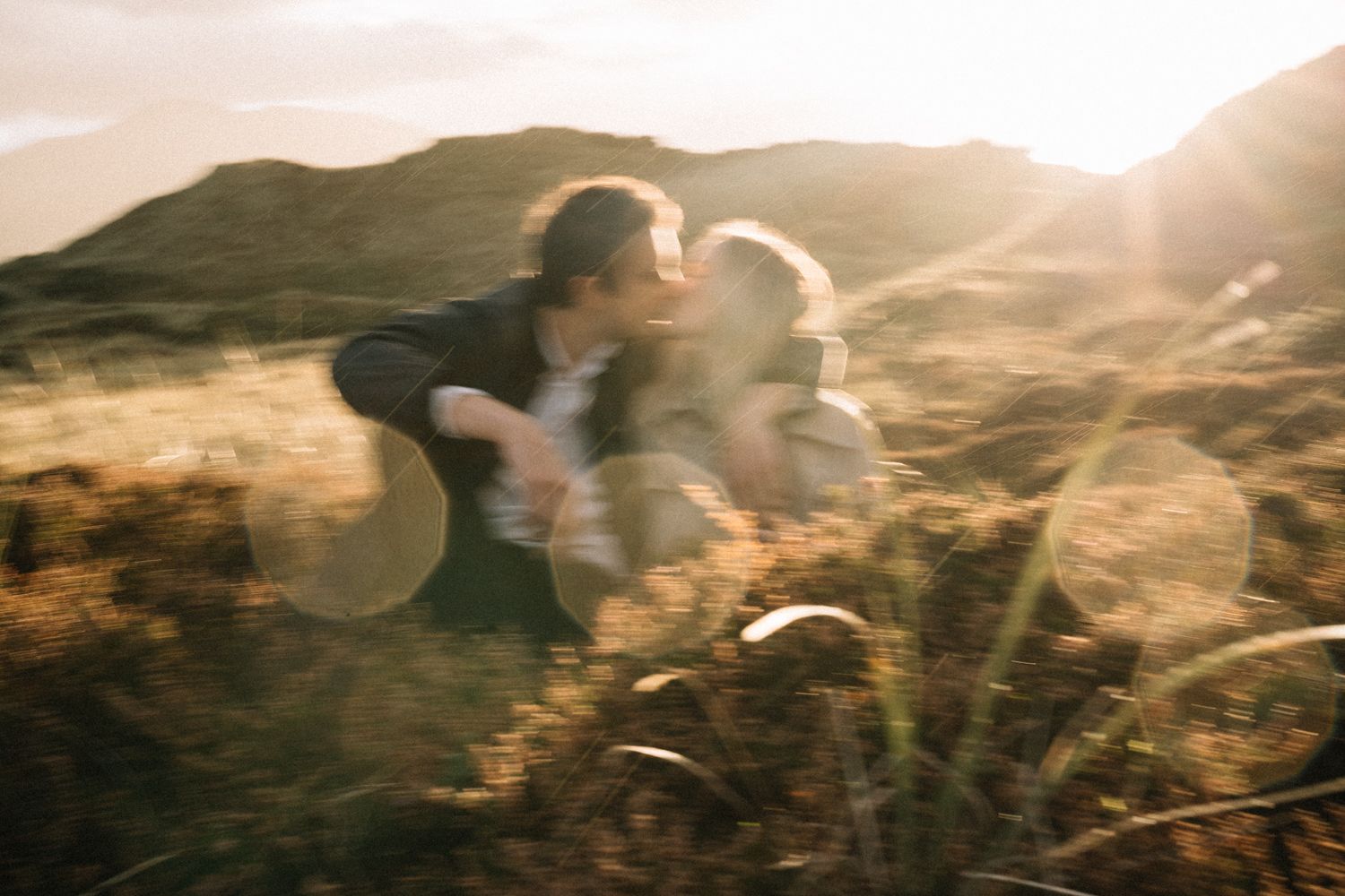 blurry-shot-of-couple-kissing-at-sunset-on-their-engagment-shoot-Film-Photographers-Northern-Ireland