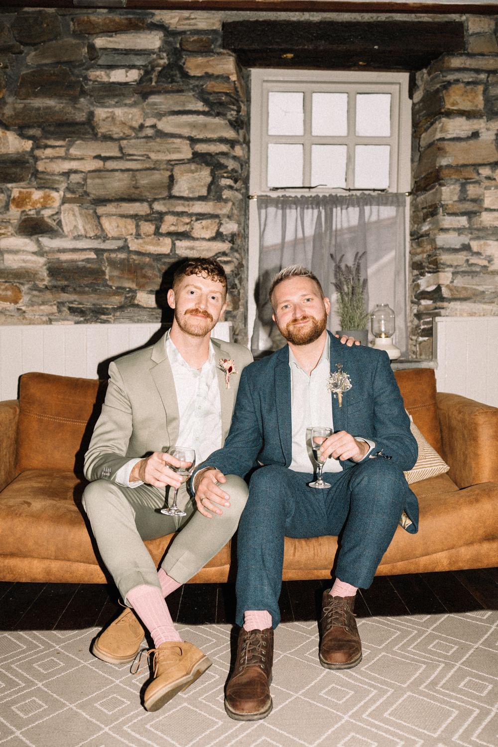grooms sitting on couch with drinks flash photography LGBTQ Wedding Photographer Ireland