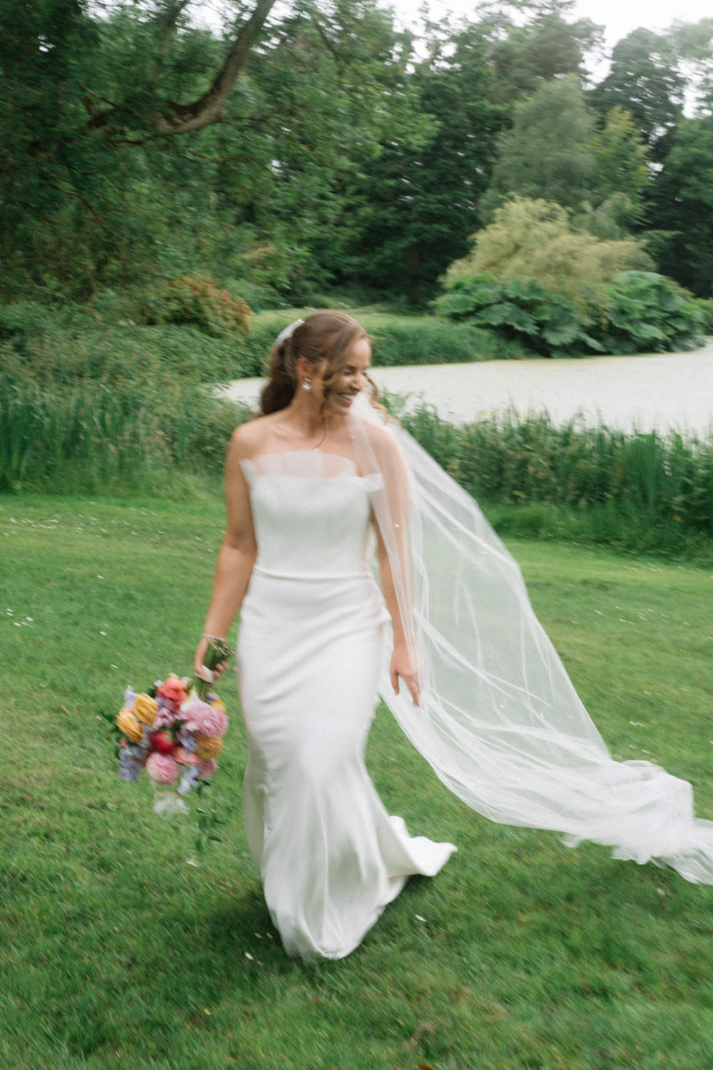 bride having fun with flowers and veil Larchfield Estate Wedding Photos