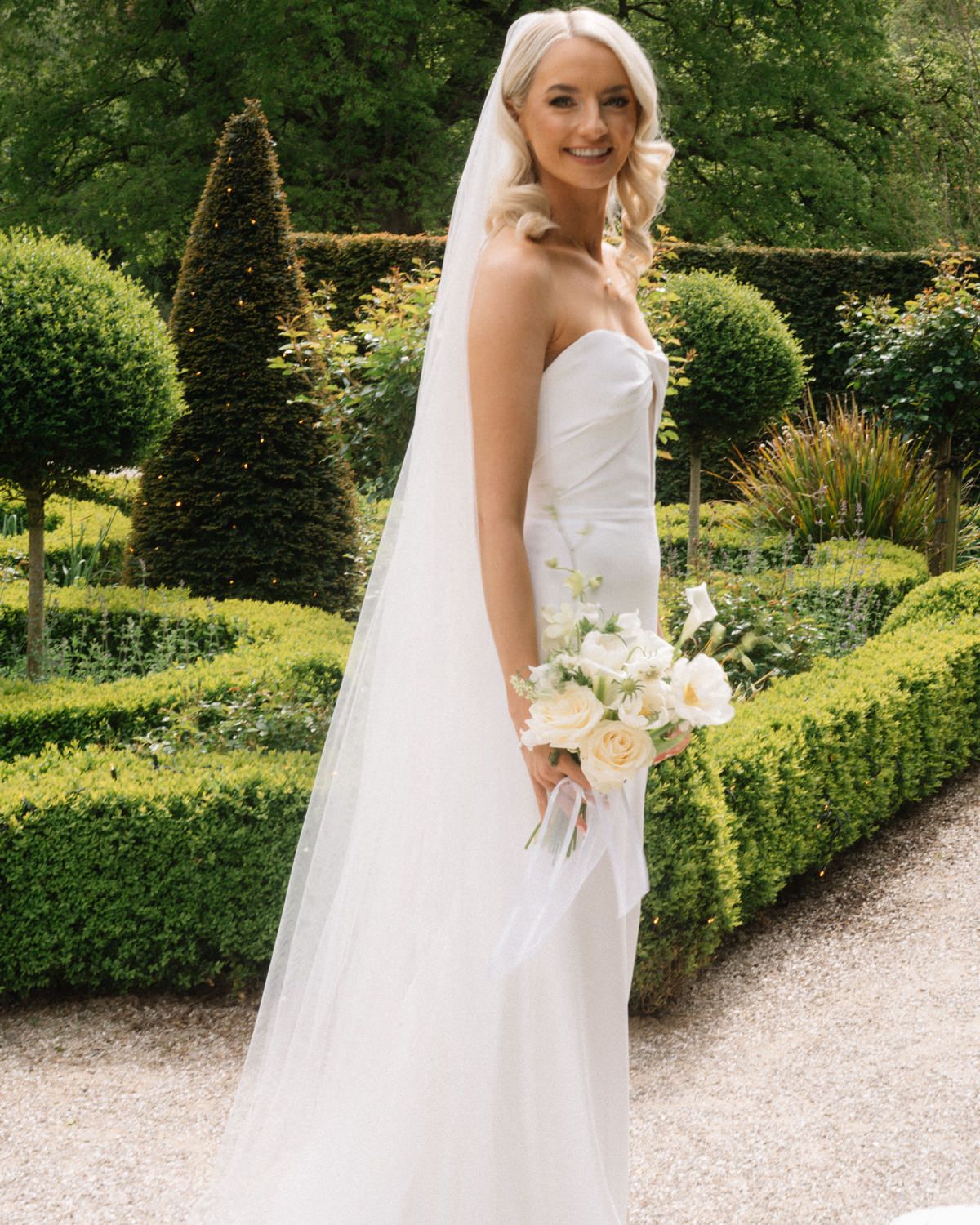 bride standing the garden with flowersCabra castle wedding