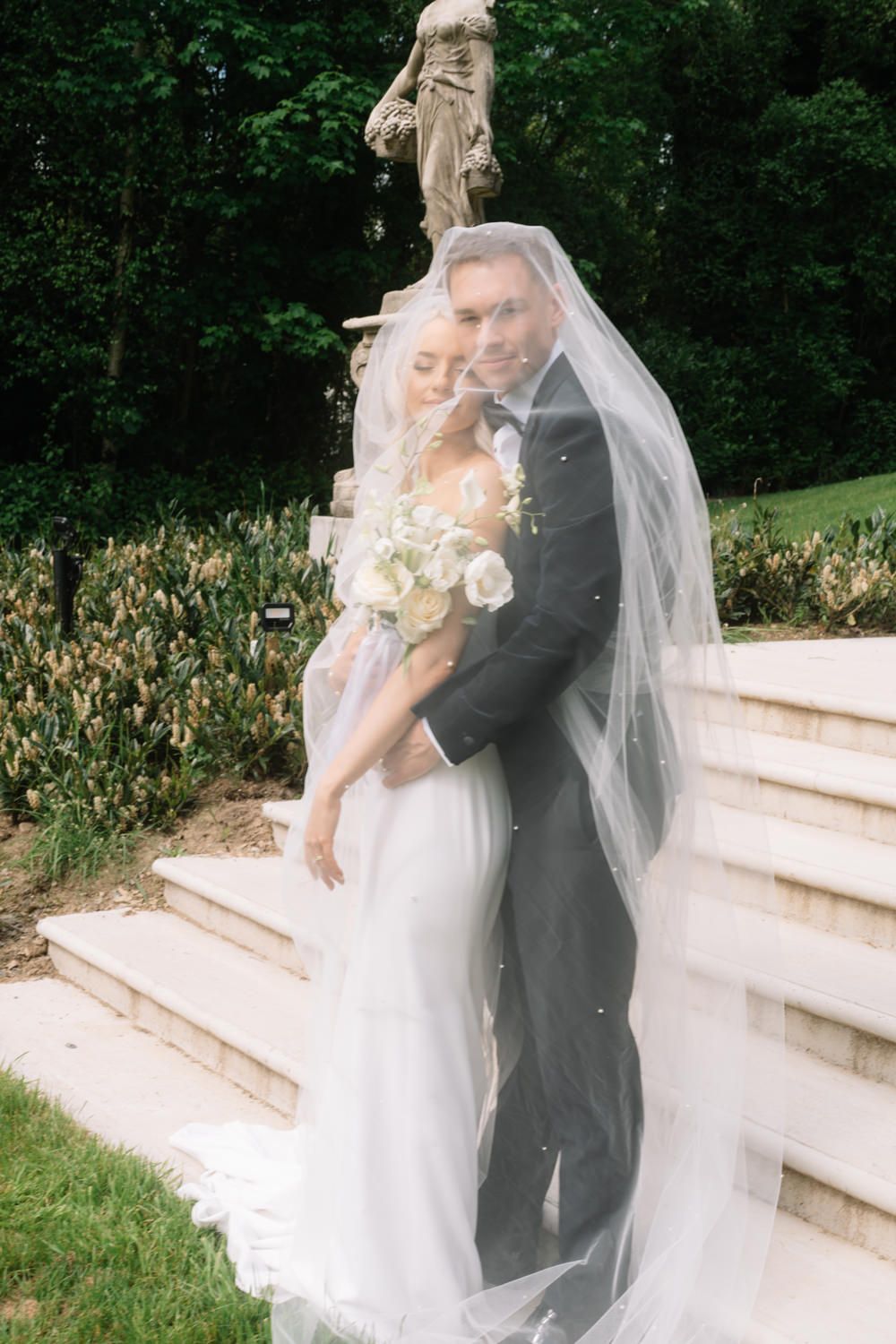 bride and groom under the veil at Cabra castle Captured by a Cabra Castle Wedding Photographer